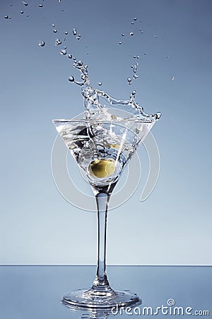 Olive splashing in a Martini glass Stock Photo