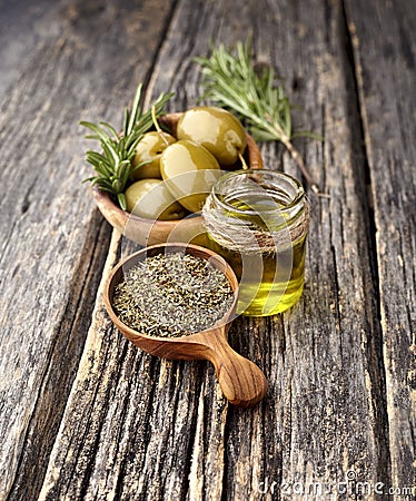 Olives with rosemary and olive oil on a wooden background Stock Photo