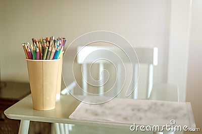 Ð¡olored pencils are on the high chair. Stock Photo