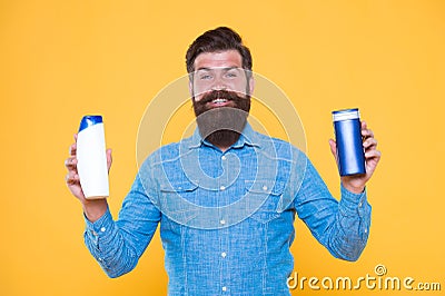 Ombine two products for best results. Liquid soap. Bath cosmetics. Man bearded hipster hold shampoo bottles. Hair care Stock Photo