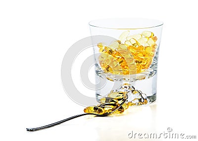 Omega-3 vitamins in glass and teaspoon Stock Photo