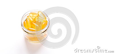 Omega 3 capsules in glass jar on white background Fish oil Yellow softgels Vitamin D, E, A supplement Banner Stock Photo