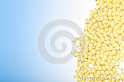 Omega-3 on gradient blue background with copy space horizontal shot. Fish oil on a white background. Yellow capsules Stock Photo