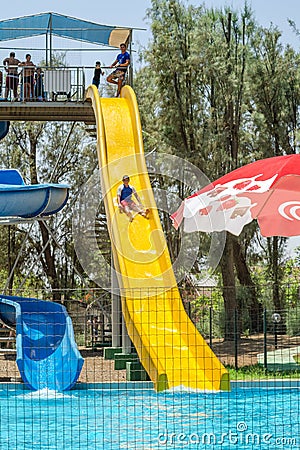 Omer, ISRAEL - July 25, 2015 in Israel Children walk down the yellow water slides in the outdoor pool Editorial Stock Photo