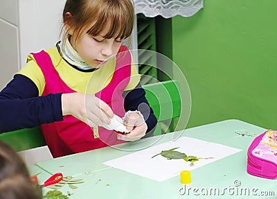 Omsk, Russia - September 24, 2011: schoolgirl glues applique at school desk Editorial Stock Photo