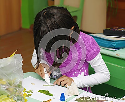 Omsk, Russia - September 24, 2011: schoolgirl glues applique at school desk Editorial Stock Photo