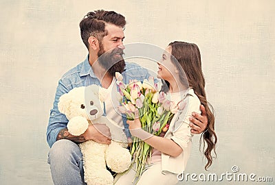 One adoption is enough to change lives. Adoptive family. Bearded man and little girl hold flowers and toy. Child Stock Photo