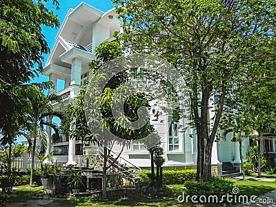 One beautiful three-story house with palm trees Stock Photo