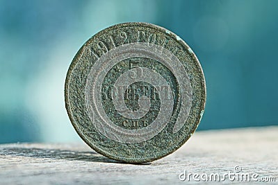 Big old copper green coin on a gray table Stock Photo