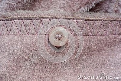 plastic round button on a suede brown pink cloth Stock Photo