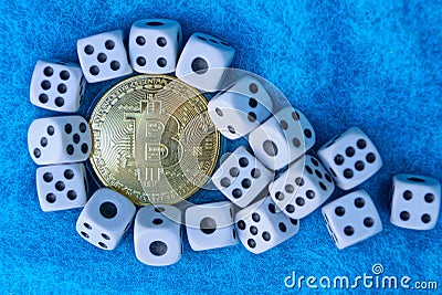 Bitcoin yellow coin and white game dice on blue wool Stock Photo