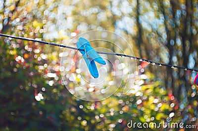One blue clothes peg hanging on a metal string Stock Photo
