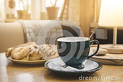 One blue cup of coffee on wooden cafeteria table in doors in morning. Stock Photo