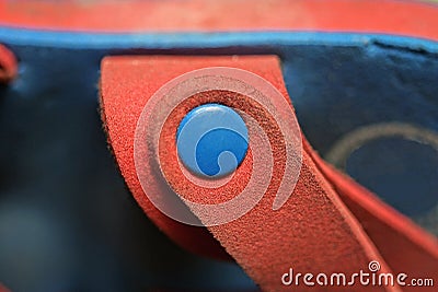 plastic rivet button on a red summer sandal harness Stock Photo