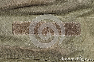 one brown plastic velcro on a green fabric Stock Photo
