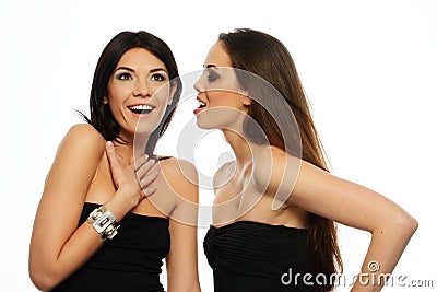 One brunette girl telling gossip to anothe Stock Photo