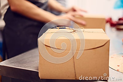 One cardboard box ready to be shipped sitting on metal grey steel table Stock Photo