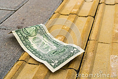 One dollar lies on the pavement Stock Photo
