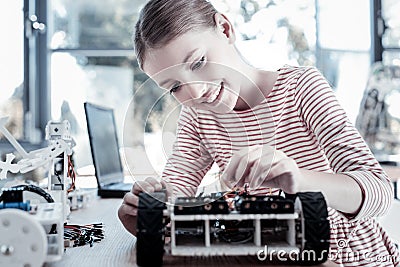 Beautiful girl smiling while constructing robotic vehicle Stock Photo