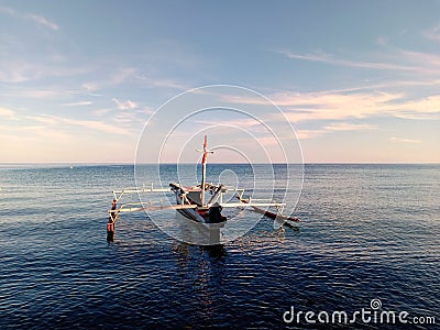 One fishing boat mooring on calm sea water Stock Photo