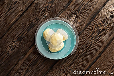 One fresh raw potato on a plate on a dark wooden Board background Stock Photo