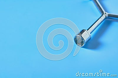 One glossy chrome wrench for nuts lies on blue desk in workshop Stock Photo