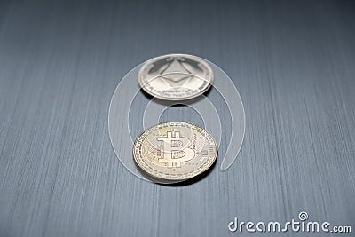 One golden bitcoin and ethereum coin on a metallic background. Cryptocurrency and business financial concept Editorial Stock Photo