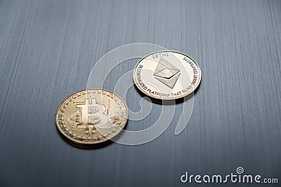 One golden bitcoin and ethereum coin on a metallic background. Cryptocurrency and business financial concept Editorial Stock Photo