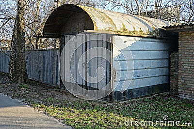 One gray closed metal garage stands outside Stock Photo