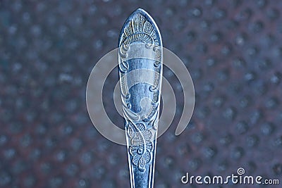 One gray old iron spoon handle with a pattern Stock Photo