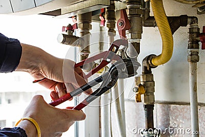 One gur repairs filter of gas boiler with wrenches Stock Photo