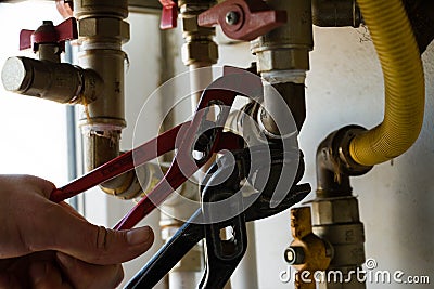 One gur repairs filter of gas boiler with wrenches Stock Photo