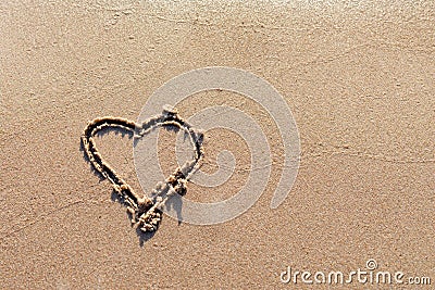 One Heart Drawn in the Sand on a Beach.soft wave of the sea.Romantic love. true love.Beige beach.Copy space Stock Photo