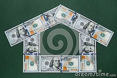 One hundred american dollars house over green background. Mortgage concept. Stock Photo