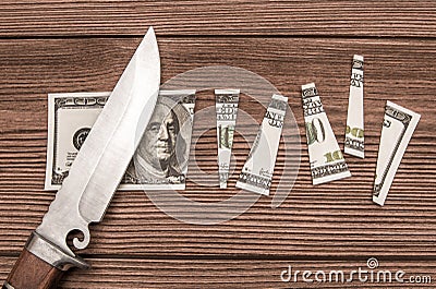 A one hundred dollar denomination cut into pieces using a knife against the background Stock Photo