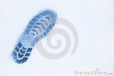 One left foot shoe print on snow, top view, copy space, cloudy a Stock Photo