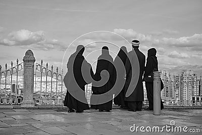 One man four women in hijab and burqa Stock Photo