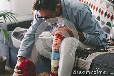One man at home doing knit activity alone sitting on the sofa. Mature male people love knitting work for no stress hobby and relax Stock Photo