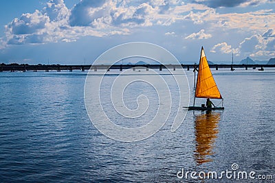 One man sailboat - single yellow sail on turquoise water - matching sky - Pumicestone Channel narrow waterway between Bribie Stock Photo