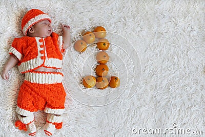 One month baby. Sleeping newborn baby one month old in orange Stock Photo