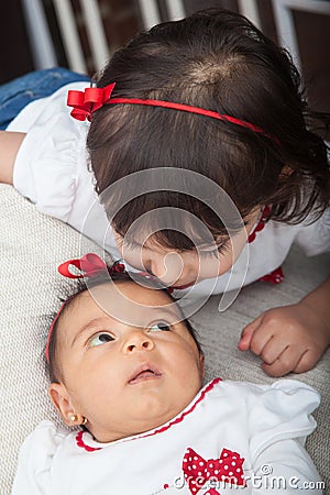 One month old baby girl at home with her big sister. Love between siblings concept. Family concept Stock Photo