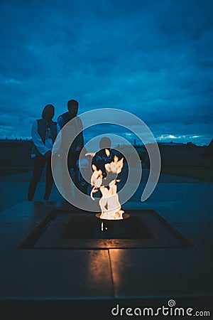 A Russian family facing the eternal flame on Marsovo Pole (Field of Mars), Saint Petersburg, Russia Editorial Stock Photo