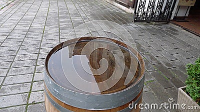 One old-fashioned wooden barrel on the pavement, after the rain Stock Photo