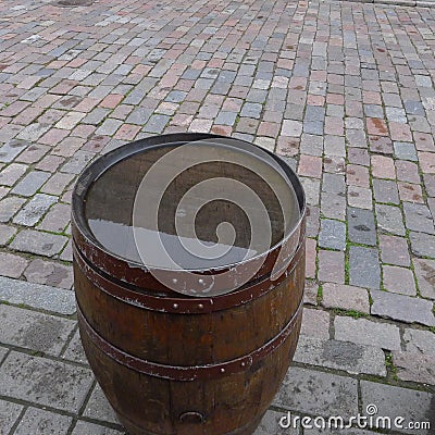 One old-fashioned wooden barrel on the pavement, after the rain Stock Photo