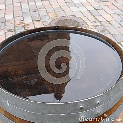 One old-fashioned wooden barrel on the pavement, after the rain Stock Photo