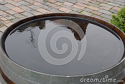 One old-fashioned wooden barrel on the pavement, after the rain Stock Photo