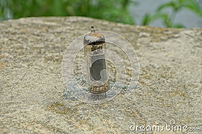 One old glass transistor lamp stands on a gray stone Stock Photo