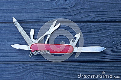 one open folding knive multitools with red handles with gray blades Stock Photo