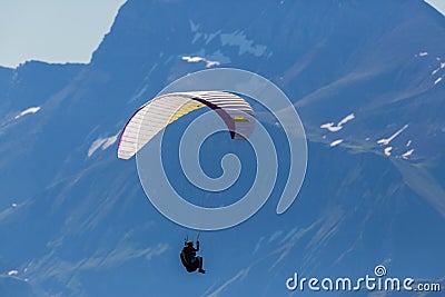 One person paragliding in the mountains Stock Photo