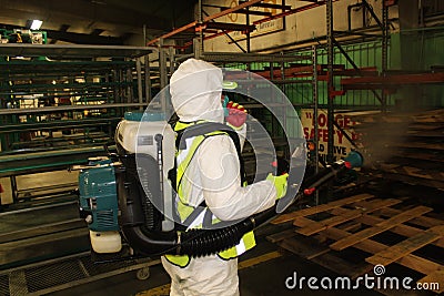 Covid-19 spraying in factory mitigation one guy Stock Photo
